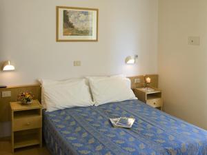 a bedroom with a bed with a tray on it at Hotel Nives in Riccione