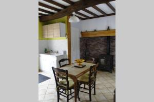 eine Küche und ein Esszimmer mit einem Tisch und Stühlen in der Unterkunft Miller's farm. Cottage on the Auhtie for 2 in Hem-Hardinval
