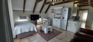 a bedroom with a bed and a kitchen with a refrigerator at Allview Selfcatering Apartments Jacobsbaai in Jacobs Bay