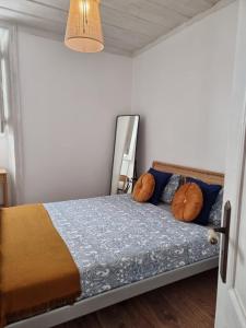 Schlafzimmer mit einem Bett mit blauen und orangefarbenen Kissen in der Unterkunft Dream Days Guesthouse in Faro