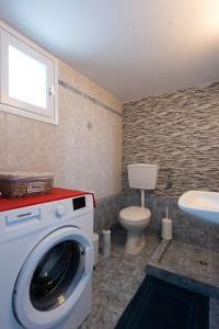 a bathroom with a washing machine and a toilet at «MARMARA» house in Cherronisos