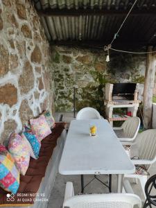 a table and chairs in a room with a stone wall at lugar del pazo nª9-albeos in Albeos