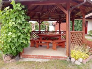 a wooden picnic table under a wooden pergola at Apartamenty Kołczewo in Kołczewo +16 photos