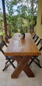a wooden table with a cat sitting on top of it at Cabana da Montanha - Sítio Pasangas in Santo Antônio do Pinhal
