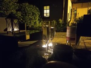 a table with two glasses and a bottle of wine at Pokoje Galeria Brama in Kazimierz Dolny