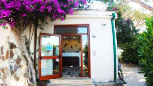 ein Gebäude mit einer Glastür und lila Blumen in der Unterkunft Hotel Rio Claro in Fondi