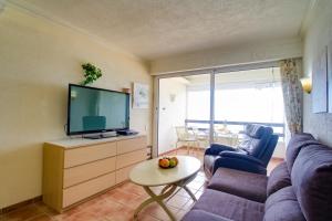 ein Wohnzimmer mit Sofa und Fernseher in der Unterkunft Ferienwohnung am Strand - 2 Schlafzimmer in Arguineguín + 34 Fotos