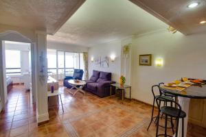 ein Wohnzimmer mit einem lila Sofa und einem Tisch in der Unterkunft Ferienwohnung am Strand - 2 Schlafzimmer in Arguineguín