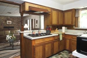 cocina con armarios de madera y horno con fogones en Kern Riverview Inn, en Kernville