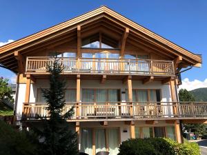 une grande maison entourée d'une terrasse. dans l'établissement Chalet Bergzeit, à Seefeld in Tirol
