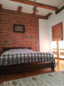 a bed in a room with a brick wall at Noclegi w domu szachulcowym dla dwóch osób in Ustka