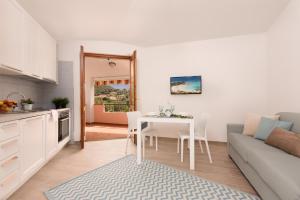 een keuken en een woonkamer met een tafel en een bank bij Sa Prenda in Villasimius