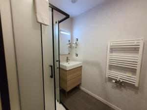 a white bathroom with a sink and a mirror at La Potinière Du Lac Appartements in Bagnoles de l'Orne +109 photos