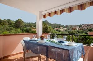 een eetkamer met een tafel en stoelen en een balkon bij Sa Prenda in Villasimius
