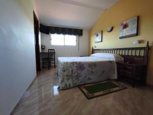 a bedroom with a bed and a table and a window at Pension Casa Carmela in A Lanzada