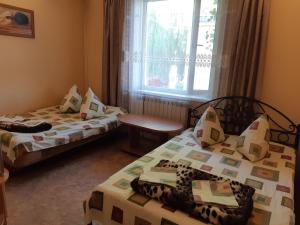 a room with two beds and a window at Мини отель Семейного типа. in Zatoka