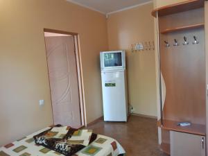 a room with a refrigerator and a tv on top of it at Мини отель Семейного типа. in Zatoka