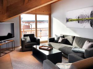 a living room with a couch and a tv at Chalet Bergzeit in Seefeld in Tirol