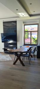 a dining room with a table and chairs in a room at Blue Door Apartment in Augustów