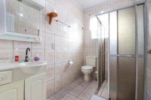 a bathroom with a toilet and a sink and a shower at Pousada Tia Eni in Gramado +67 photos
