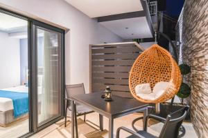 a room with a table and chairs and a hanging chair at Oasis in Sarti