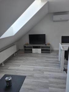 uma sala de estar com uma televisão de ecrã plano numa cómoda em Rok Apartment em Bled
