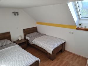 two twin beds in a room with a window at Rok Apartment in Bled