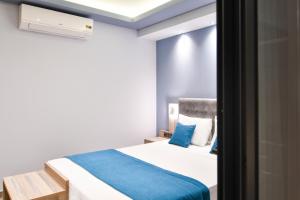 a small bedroom with a bed with blue pillows at Oasis in Sarti
