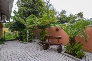a bench in a courtyard with trees and plants at Pousada Tia Eni in Gramado