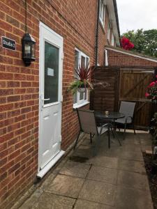 a patio with a door and a table and chairs at Studio-2 Staines,Heathrow, London-own entrance in Staines