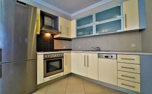 a kitchen with white cabinets and a stainless steel refrigerator at Zigouris House in Parga