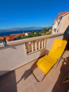 a yellow chair on a balcony with a view at The View in Supetar