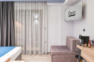 a bedroom with a bed and a chair and a window at Oasis in Sarti