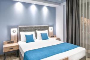 a bedroom with a large white bed with blue pillows at Oasis in Sarti