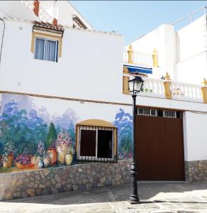 a mural on the side of a building with a street light at Casa Arte de Sorvilan in Sorvilán