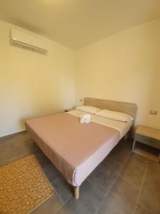 a bedroom with a large bed with two pillows at Affittacamere Samar in San Teodoro