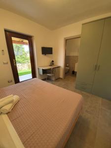 a bedroom with a bed and a desk and a television at Affittacamere Samar in San Teodoro