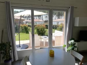 a room with a table and a sliding glass door at Appartement proche lac et plage in Léon