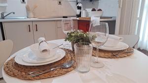 a table with white plates and wine glasses on it at Alameda11 in Cádiz