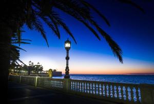 a street light next to the ocean at night at Alameda11 in Cádiz