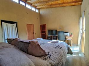 a bedroom with a bed and a television in it at Casa de Adobe in Isla de Maipo