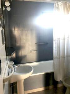 y baño con lavabo, aseo y bañera. en Arenas B&B- Casa Compartida en Puerto Madryn