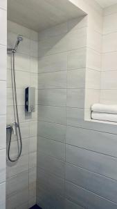 a shower in a bathroom with white tiles at Aisa 39 in Pärnu