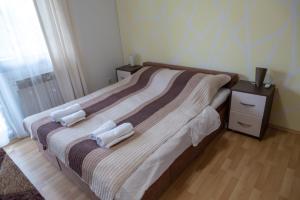una camera da letto con un letto e due asciugamani di Sun Garden Sarajevo a Sarajevo
