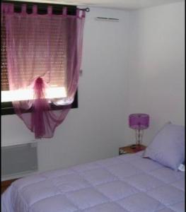1 dormitorio con cama y ventana con cortina púrpura en Appartement spacieux 3 chambres, en Génos