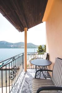 einen Balkon mit Tisch, Stühlen und Wasser in der Unterkunft Sunny Apartment Stella in Rava