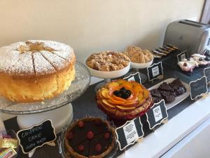 una tavola con diversi tipi di torte e altri dolci di La terrazza sulle vigne B&B a Corte Franca