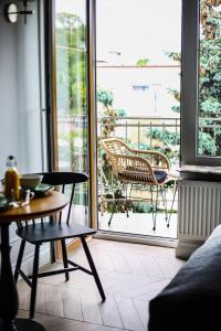 a room with a table and chairs on a balcony at Zielony Dom in Mielno