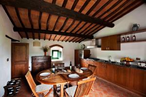 una cocina con una mesa de madera con sillas y un asterisco en Villa Rosano, en Greve in Chianti