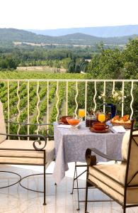 a table and two chairs with food on a balcony at La Bergerie in Joucas